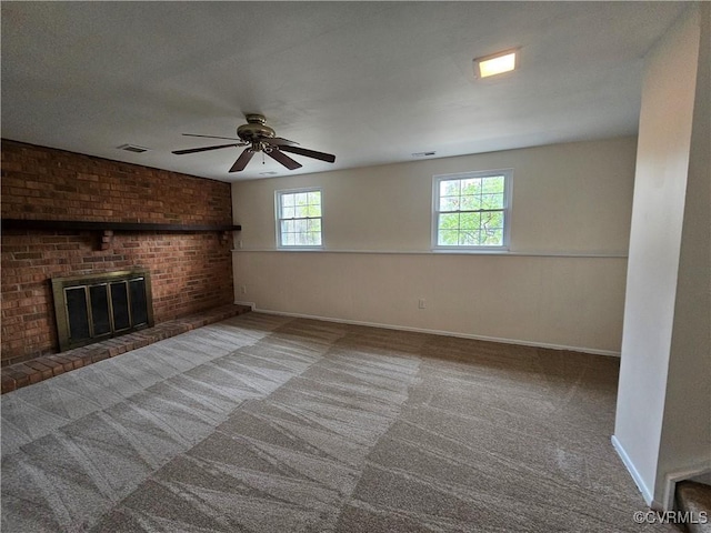 unfurnished living room with visible vents, a fireplace, carpet flooring, baseboards, and ceiling fan