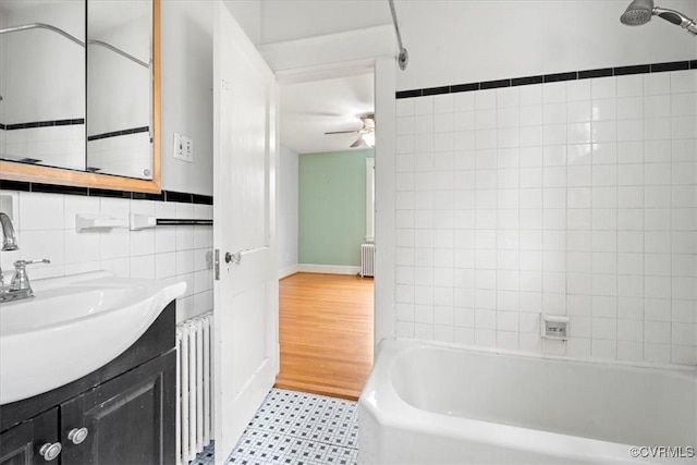 full bath featuring vanity, tile walls, radiator heating unit, and a ceiling fan