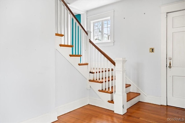 staircase with baseboards and hardwood / wood-style flooring