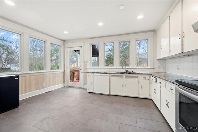 kitchen featuring dishwasher, decorative backsplash, stainless steel range with electric cooktop, white cabinets, and a sink