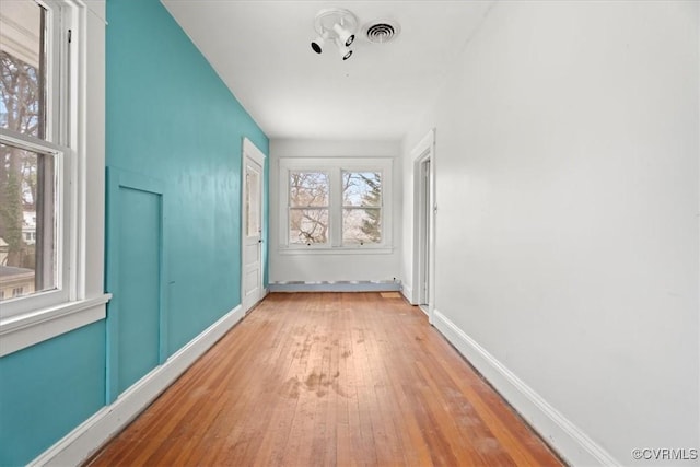 interior space featuring visible vents, light wood-style flooring, and baseboards