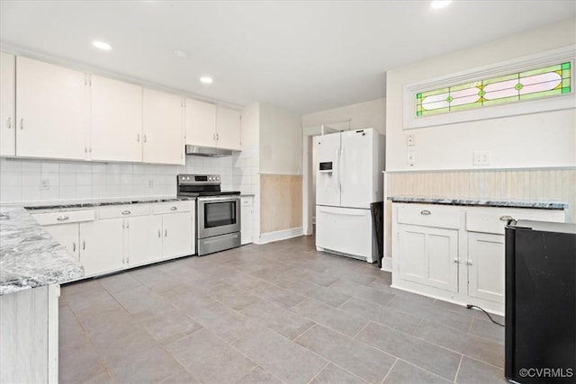 kitchen featuring under cabinet range hood, stainless steel electric stove, backsplash, white cabinetry, and white fridge with ice dispenser