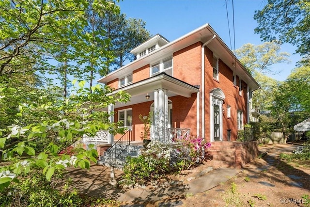 view of front facade featuring brick siding and covered porch