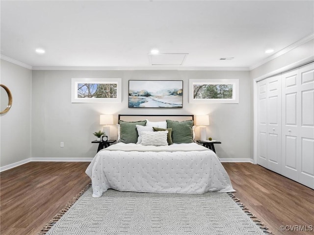 bedroom featuring visible vents, baseboards, wood finished floors, and crown molding