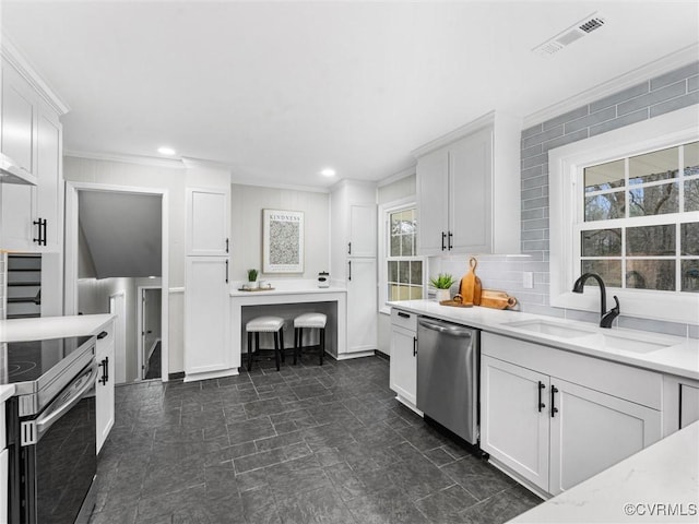 kitchen with visible vents, a sink, tasteful backsplash, appliances with stainless steel finishes, and white cabinets