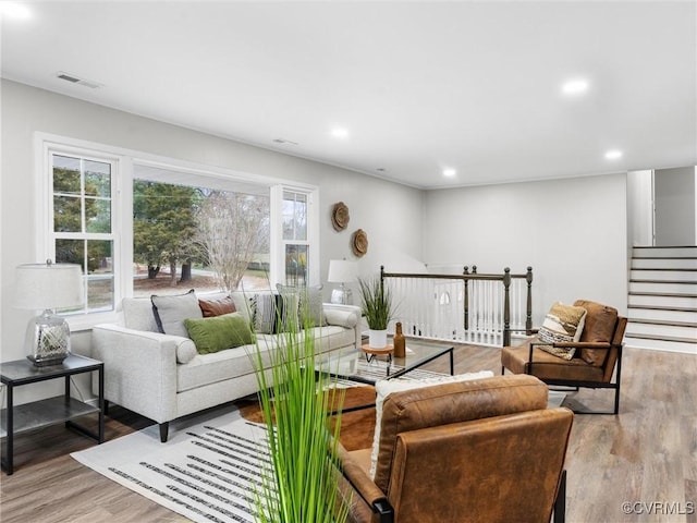 living area featuring visible vents, recessed lighting, stairway, and wood finished floors