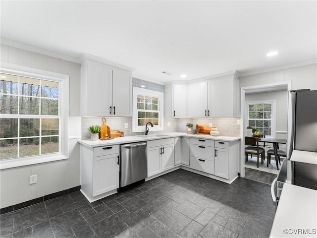 kitchen with light countertops, plenty of natural light, appliances with stainless steel finishes, and a sink