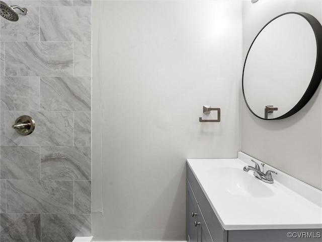 bathroom with vanity and a tile shower