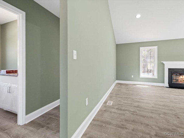 0 Silver Trail Cir, Lawrenceville, VA 23868 - unfurnished living room featuring lofted ceiling, wood finished floors, a fireplace with flush hearth, and baseboards