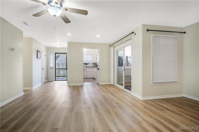 spare room featuring visible vents, baseboards, light wood-style floors, and a ceiling fan