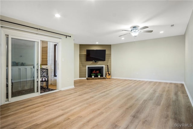 unfurnished living room with light wood-style flooring, baseboards, and a ceiling fan