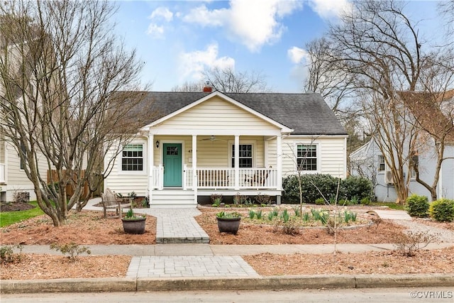 bungalow-style house with a porch, a ceiling fan, and a shingled roof