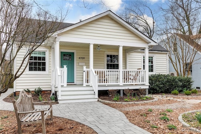 bungalow with covered porch, a ceiling fan, and a shingled roof