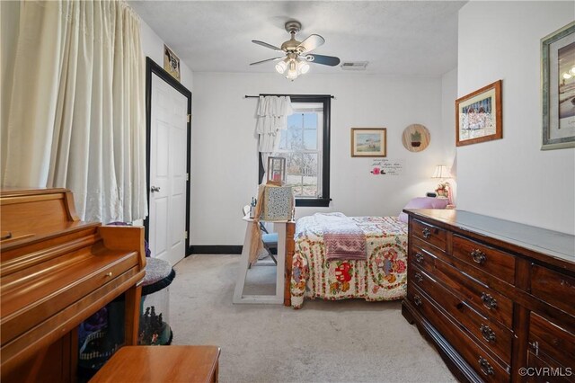 bedroom with light carpet, visible vents, and ceiling fan