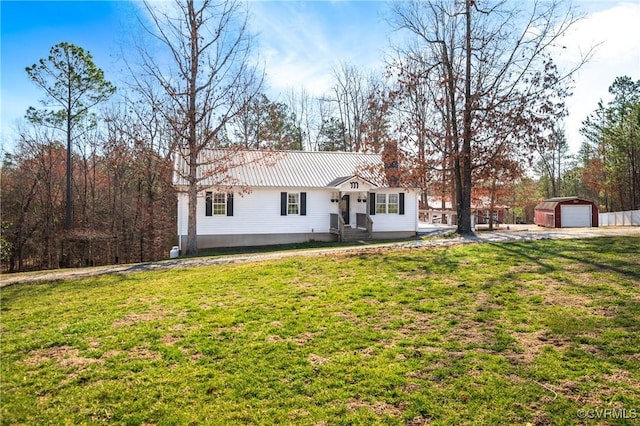 ranch-style house featuring an outdoor structure, a detached garage, a front lawn, and metal roof