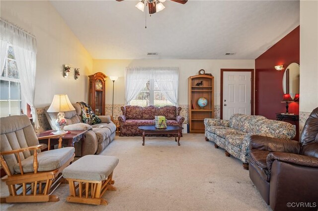 living room featuring ceiling fan, vaulted ceiling, visible vents, and carpet