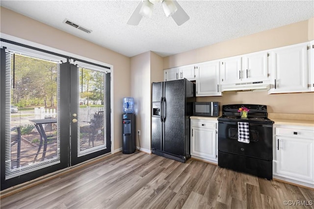kitchen featuring a textured ceiling, visible vents, black appliances, under cabinet range hood, and french doors