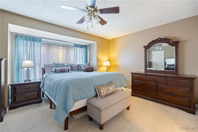 bedroom featuring light carpet, ceiling fan, and a textured ceiling