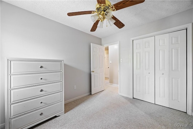carpeted bedroom with a closet, baseboards, ceiling fan, and a textured ceiling