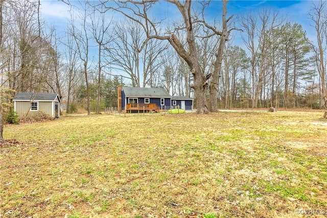 view of yard featuring an outdoor structure and a deck