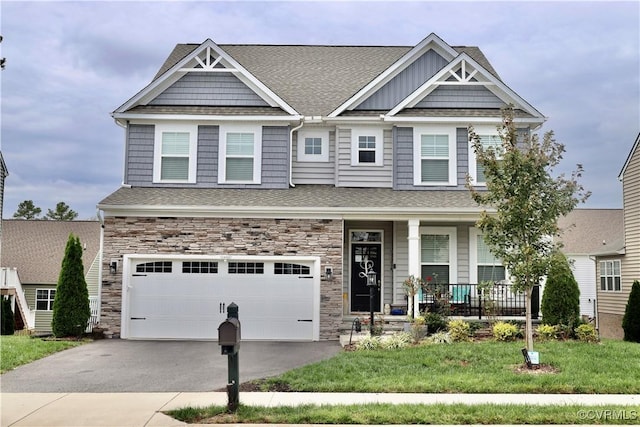 view of front of house with covered porch, asphalt driveway, an attached garage, and roof with shingles