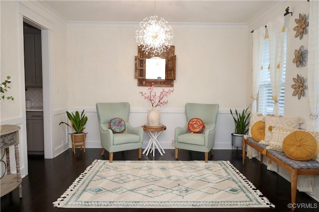 sitting room with dark wood finished floors, a chandelier, and crown molding