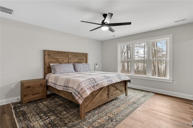 bedroom featuring visible vents, baseboards, and wood finished floors