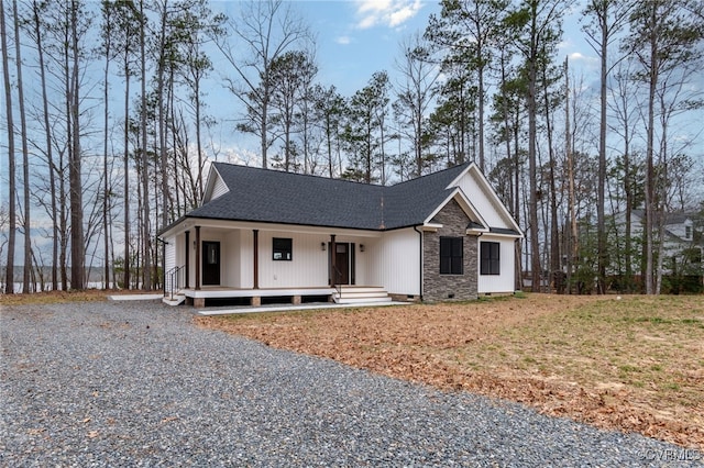 view of front of property featuring a shingled roof, covered porch, and crawl space