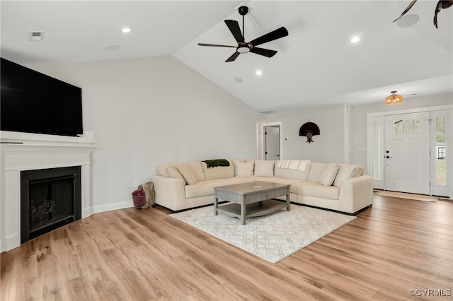 living area with ceiling fan, light wood-type flooring, a fireplace, recessed lighting, and vaulted ceiling