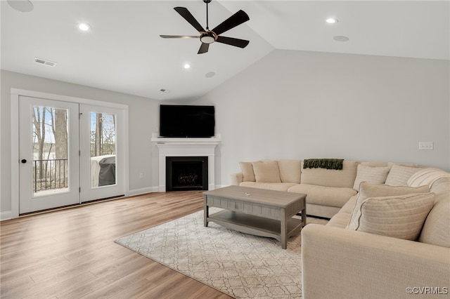 living room with light wood-style floors, a ceiling fan, vaulted ceiling, visible vents, and recessed lighting