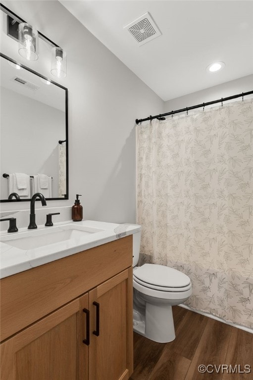 full bathroom featuring vanity, visible vents, recessed lighting, toilet, and wood finished floors