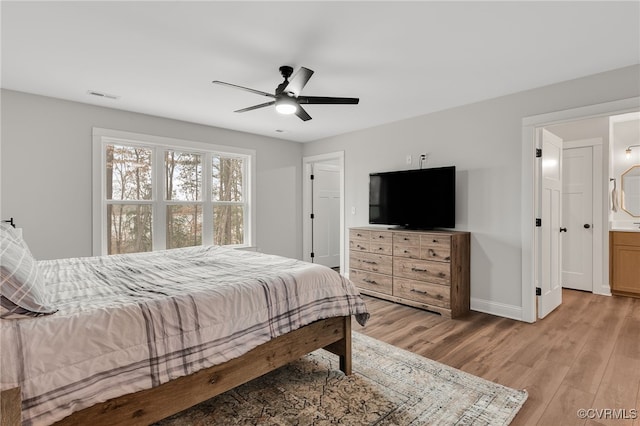 bedroom with light wood finished floors, visible vents, baseboards, and a ceiling fan