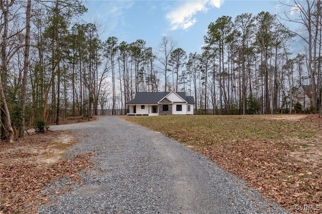 view of front facade featuring gravel driveway and a front yard