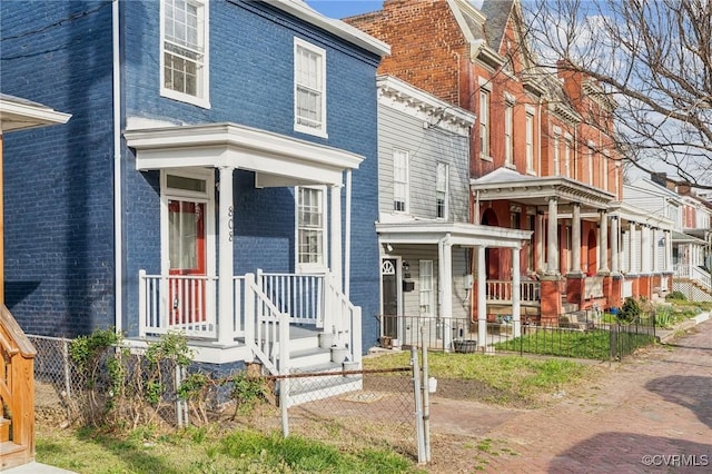 view of front of home featuring brick siding and fence