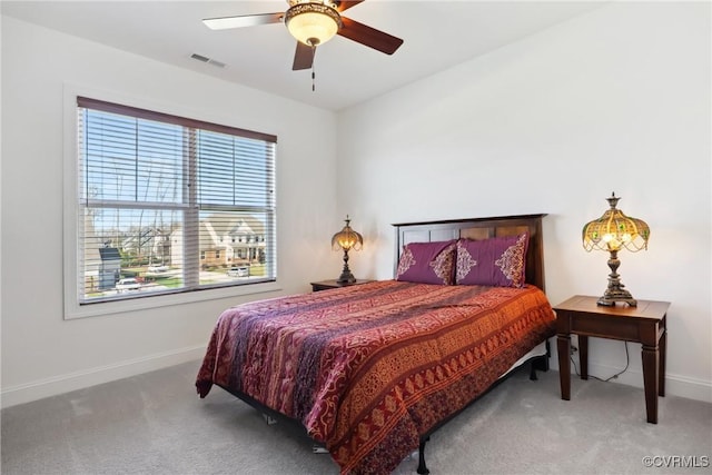 carpeted bedroom featuring visible vents, baseboards, and ceiling fan