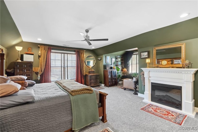 bedroom with ceiling fan, carpet, a glass covered fireplace, recessed lighting, and lofted ceiling