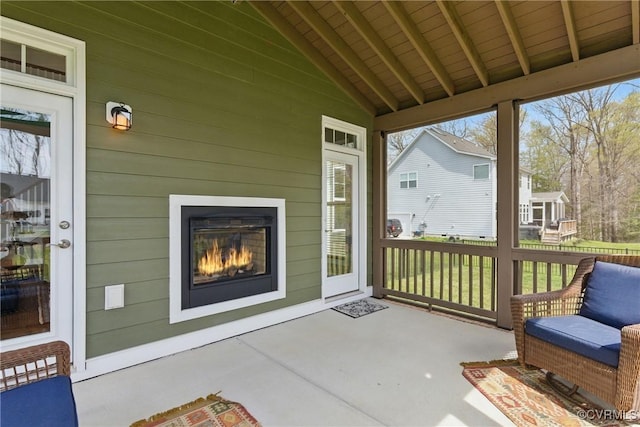 sunroom / solarium with a glass covered fireplace and beam ceiling