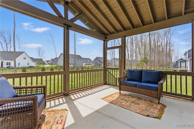 sunroom / solarium with beamed ceiling, outdoor lounge area, and a residential view