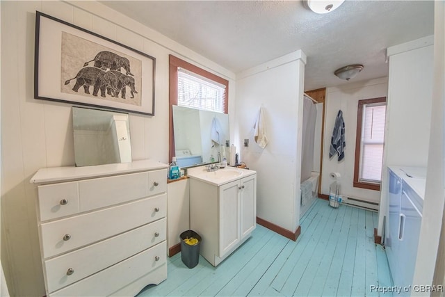 257 Horseshoe Bend Rd, Deltaville, VA 23043 - full bath with vanity, a baseboard radiator, wood-type flooring, baseboards, and shower / bath combo with shower curtain