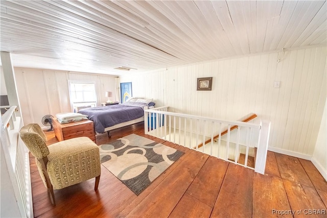 257 Horseshoe Bend Rd, Deltaville, VA 23043 - bedroom featuring wood-type flooring, wood walls, and baseboards
