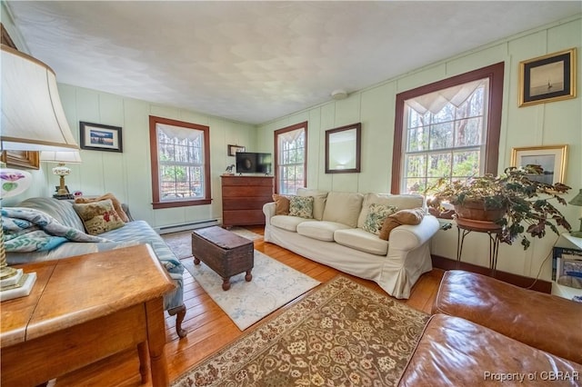 257 Horseshoe Bend Rd, Deltaville, VA 23043 - living area featuring baseboard heating, wood finished floors, and a decorative wall