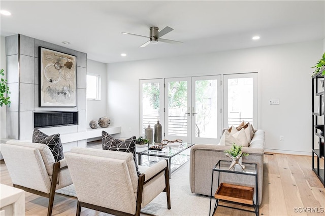 living room with light wood finished floors, a ceiling fan, and recessed lighting