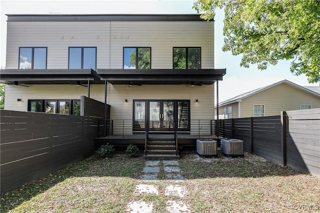 back of property featuring central AC unit, a fenced backyard, and french doors