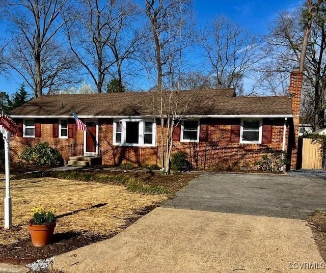 ranch-style home with brick siding and a chimney