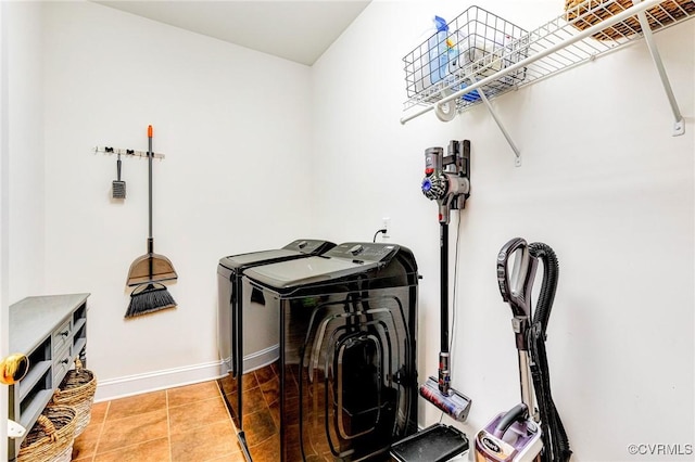 laundry room with laundry area, baseboards, separate washer and dryer, and tile patterned flooring