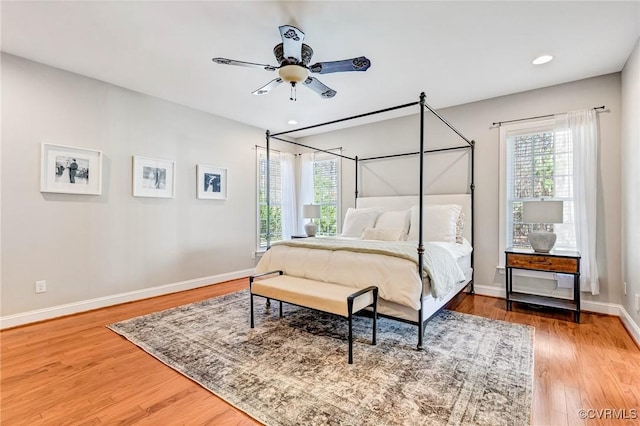 bedroom with baseboards, multiple windows, recessed lighting, and wood finished floors