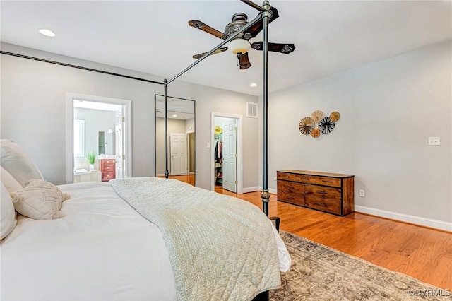 bedroom featuring a walk in closet, recessed lighting, visible vents, and wood finished floors