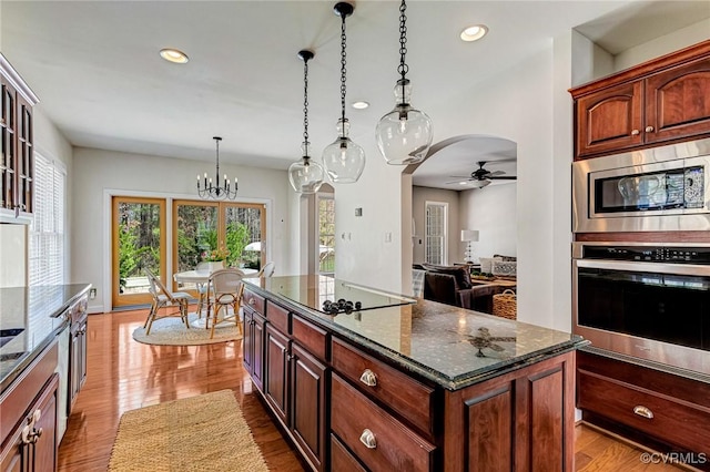 kitchen with recessed lighting, a center island, decorative light fixtures, ceiling fan with notable chandelier, and stainless steel appliances