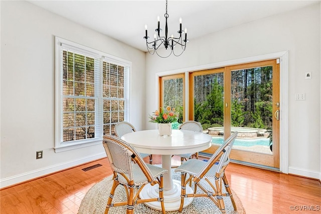 dining space with baseboards, a chandelier, and plenty of natural light