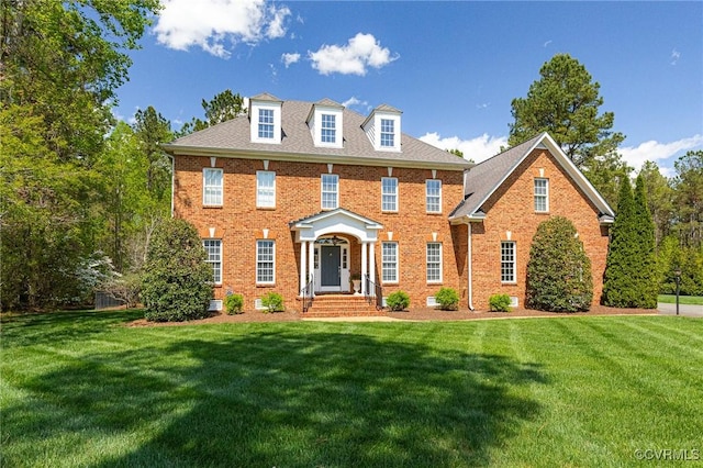 georgian-style home with brick siding and a front yard